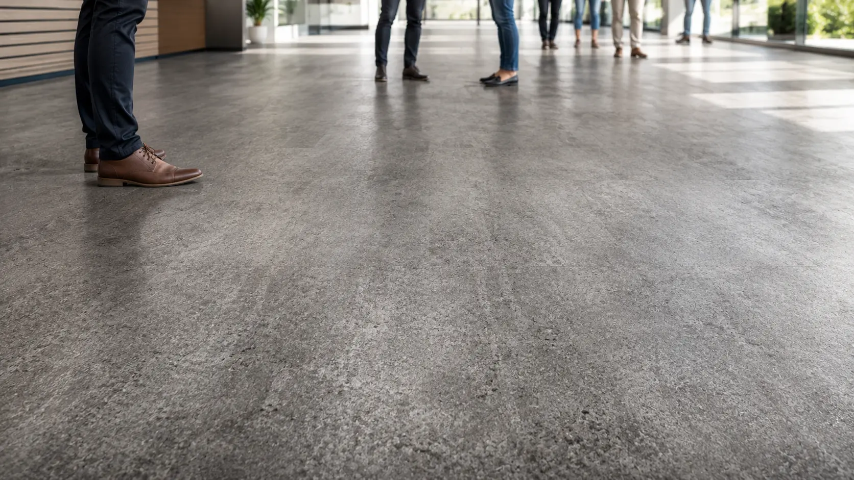 Close-up texture of commercial vinyl flooring showing wear layer and surface detail